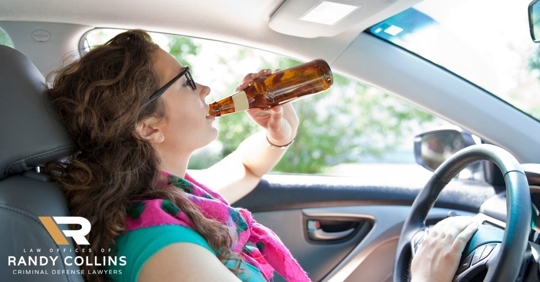 young girl drinking beer behind the wheel