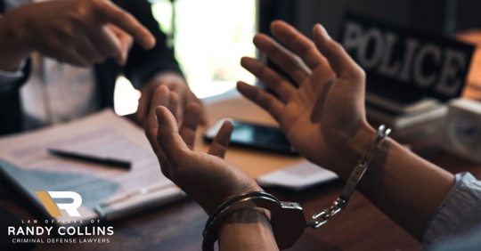 man in handcuffs feeling stressed while police officer points to him across table