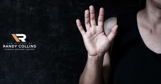 man with hand up, black background