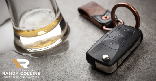 car keys next to a glass of alcohol
