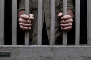 person holding jail bars